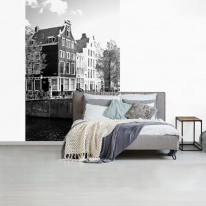 Behang - Fotobehang Grachtenpanden in Amsterdam naast een brug - zwart wit - Breedte 170 cm x hoogte 260 cm